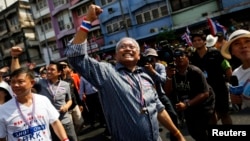 Protest leader Suthep Thaugsuban (C) greets his supporters as he leads thousands of anti-government demonstrators marching in Bangkok, Thailand Jan. 9, 2014.