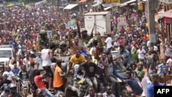 People celebrate in the streets with members of Guinea's armed forces after the arrest of President Alpha Conde in a coup d'etat in Conakry, Sept. 5, 2021.