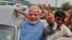 Hindu nationalist Narendra Modi, the prime ministerial candidate for India's Bharatiya Janata Party (BJP), gestures towards his supporters from his car during a road show upon his arrival at the airport in New Delhi, May 17, 2014.