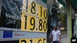 A stock monitor shows exchange rates on a storefront in Mexico City, Mexico, May 31, 2019.