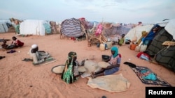 ARCHIVO - Fatouma Abubakr, de 70 años, que huyó del conflicto en la región de Darfur en Sudán, sentada con su hija afuera de su refugio improvisado en Adre, Chad, el 5 de agosto de 2023.