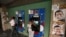 People withdraw money from cash machines where election propaganda supporting Venezuela's President Hugo Chavez cover the nearby walls in Caracas, February 8, 2013. 