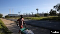 FILE - A man pushes a wheelbarrow past Namibia's power utility Nampower in Windhoek, Namibia.