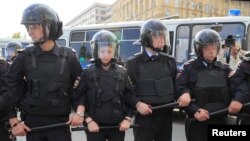 Police officers stand guard during a rally during recent demonstrations in Moscow.