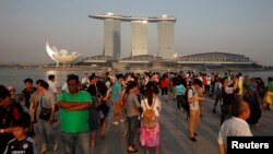 Para wisatawan menikmati suasana di Marina Bay Singapura setelah Sabtu (22/6). Kualitas udara di Sigapura dilaporkan membaik, Minggu (23/6), setelah pemerintah Indonesia melakukan upaya pemadaman kebakaran hutan dengan menjatuhkan bom air.