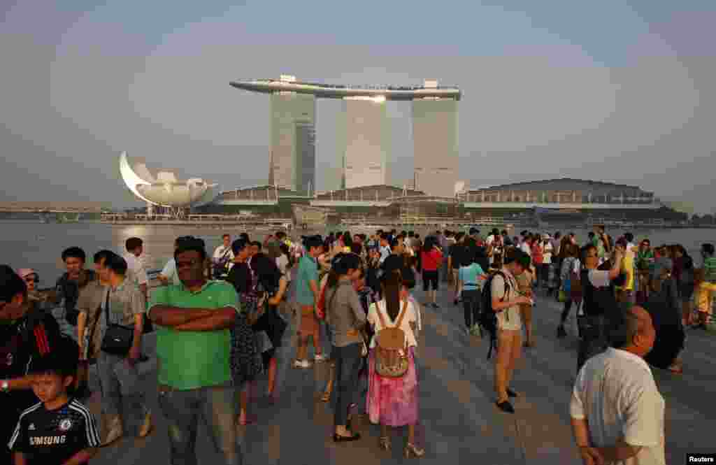 Para turis mengambil foto setelah kabut asap berkurang di Singapura (22/6). (Reuters/Edgar Su)