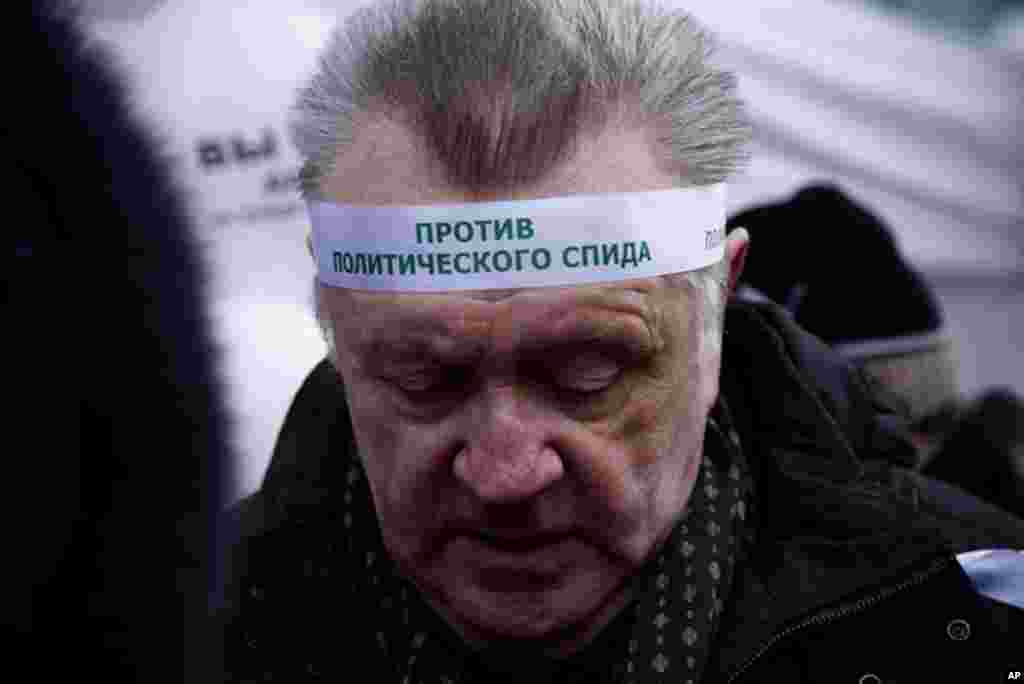 One protester wore a head ban against "political AIDS," December 24, 2011. (VOA - Y. Weeks)