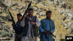 Afghan resistance movement and anti-Taliban uprising forces patrol along a road at the Rah-e Tang in Panjshir province on August 25, 2021, following Taliban's military takeover of Afghanistan. 