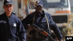 Un policier algérien surveille les corps des victimes après l'attaque à In Amenas, le 21 janvier 2012.