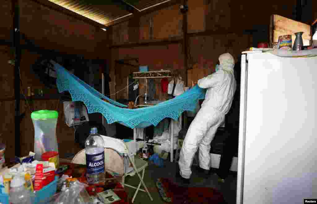 A municipal health care worker examines the body of Rocimar Fernandes dos Santos, who died at home at the age of 43 after reporting symptoms consistent with COVID-19 in Manaus, Brazil, Jan. 12, 2021.