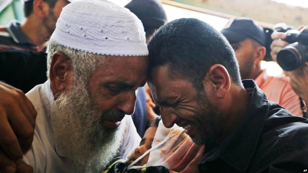 Thân nhân ôm bé trai 4 tuổi thiệt mạng vì pháo kích ở Rafah, Dải Gaza, ngày 15/7/2014. 