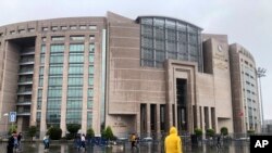 People walk outside the Justice Palace, in Istanbul, Sept. 20, 2019. Two reporters appeared in court accused of trying to undermine Turkey's economic stability. 