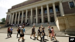 FILE - People walk past Widener Library, on the campus of Harvard University, in Cambridge, Massachusetts, July 16, 2019. Enrollment of international students is up following a drop during the pandemic, a 2022 report shows. 