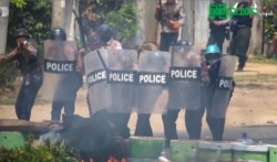 This screengrab provided via AFPTV and taken from a broadcast by Myitkyina News Journal on March 27, 2021 shows security forces crack down protesters during a demonstration against the military coup in Myitkyina in Myanmar's Kachin state.