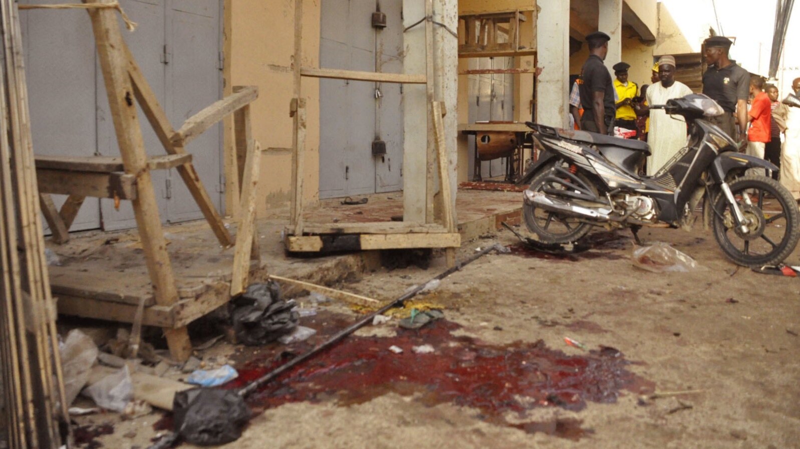 Nigerian troops gather evidence at the scene of suicide blasts that killed four people in Kano, Dec. 10, 2014. 