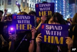 People hold placards and light up their smartphones as they take part in a rally at the financial district in Hong Kong, Aug. 28, 2019. Several thousand people protest against what they called sexual violence by the police.