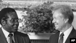 FILE - President Jimmy Carter meets with Zimbabwe Prime Minister Robert Mugabe in the Oval Office in Washington, on Aug. 27, 1980. (AP Photo/Barry Thumma, File)