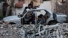 Palestinian children gather at a destroyed vehicle, amid the Israel-Hamas conflict, in Khan Younis, in the southern Gaza Strip, Oct. 27, 2024. 