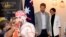 Britain's Prince Harry, center, and his wife Meghan, right, the Duchess Sussex attend a lunchtime reception hosted by Prime Minister Scott Morrison with Invictus Games competitors, their family and friends in the city's central parkland in Sydney, Austral