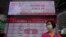 A woman wearing face mask walks past a bank electronic board showing the Hong Kong share index at Hong Kong Stock Exchange Tuesday, June 2, 2020. Shares were mostly higher in Asia on Tuesday, lifted by moves to reopen many regional economies from…