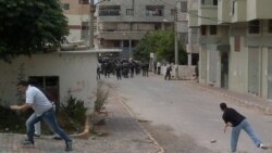 معترضان در حال پرتاب سنگ به سمت نیروهای امنیتی سوریه در شهر ساحلی بانیاس - ۲۷ مه ۲۰۱۱