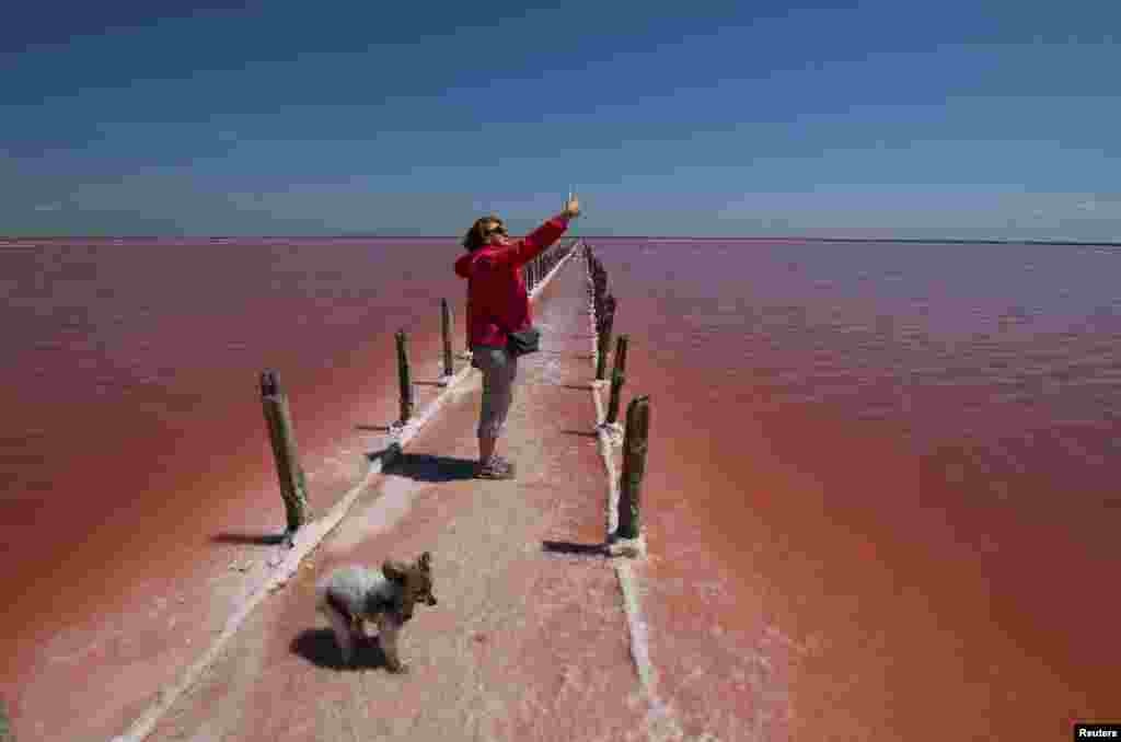 A woman takes a selfie at a salt production site on the bed of a drained area of the Sasyk-Sivash lake near the city of Yevpatoria, Crimea.