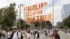 FILE - Demonstrators hold signs as they participate in the "Families Belong Together: Freedom for Immigrants" march in Los Angeles, June 30, 2018. 