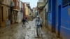 A man wearing protective jumpsuit takes part in cleaning works in a street covered in mud in Paiporta, south of Valencia, eastern Spain, Nov. 13, 2024 in the aftermath of deadly flooding. 