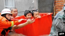 Des secouristes évacuent des enfants suite aux inondations causées par le typhon Megi à Ningde, dans la province du Fujian, dans l'est du pays, le 28 septembre 2016.