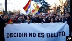 The president of Catalonian Parliament, Roger Torrent, center, and the Catalan regional President Quim Torra, center right, hold a placard that reads in Spanish: " To Choose is not a Crime", outside the Spanish Supreme Court in Madrid, Tuesday, Feb. 12, 2019.