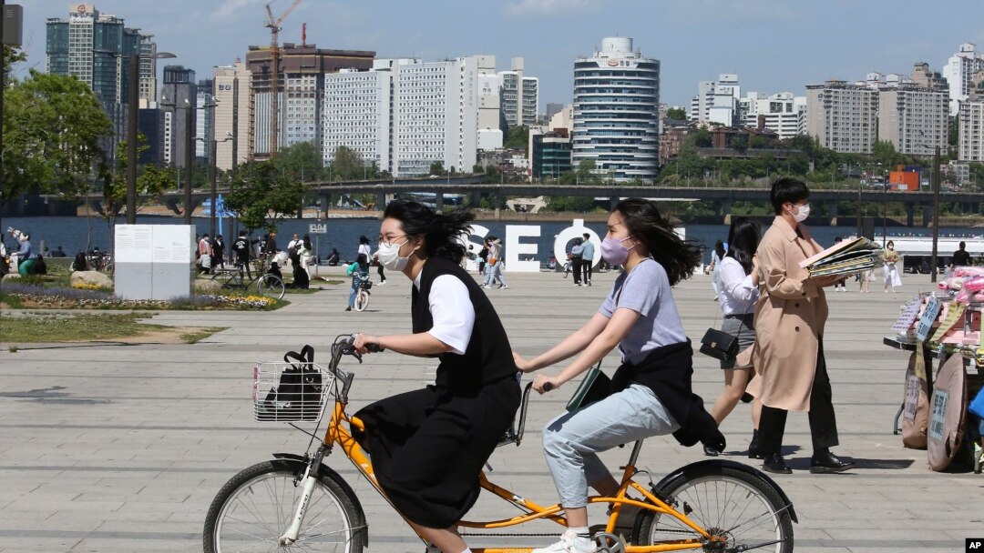 한국 수도 서울 시민들이 한강공원에서 마스크를 쓴 채 자전거를 타고 있다. (자료사진)