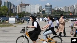 한국 수도 서울 시민들이 한강공원에서 마스크를 쓴 채 자전거를 타고 있다. (자료사진)