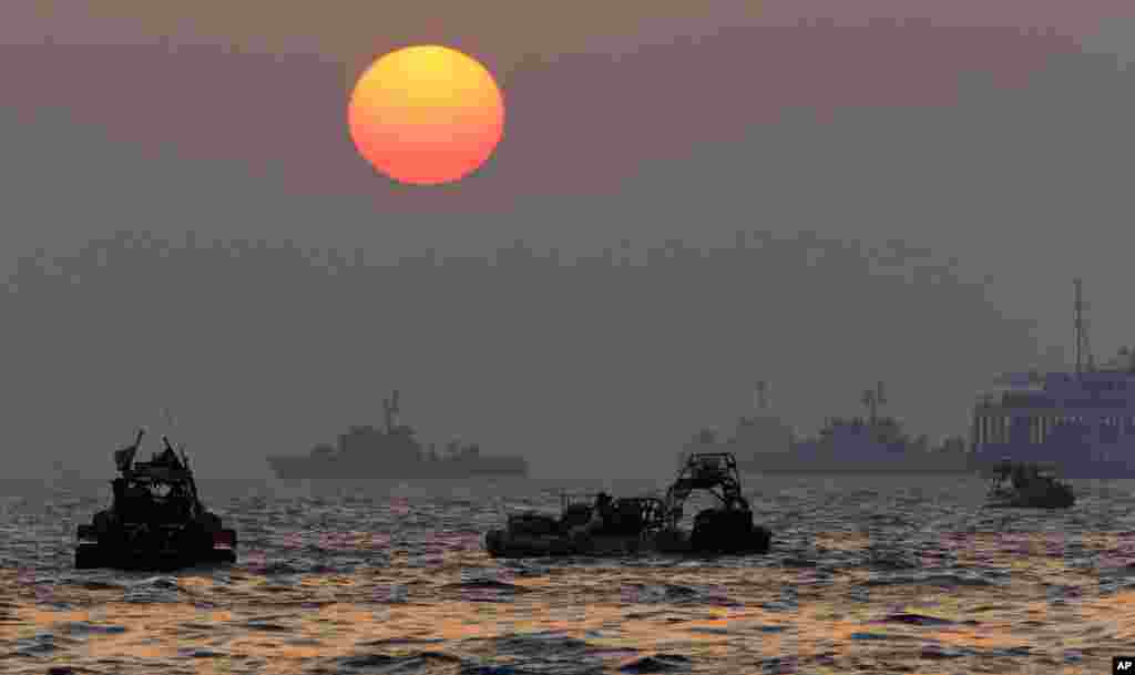 The sun sets as searchers and divers look for bodies of passengers believed to have been trapped in the sunken ferry Sewol in the water off the southern coast near Jindo, South Korea, April 22, 2014.