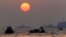 The orange sun begins to set as searchers and divers look for bodies of passengers believed to have been trapped in the sunken ferry Sewol in the water off the southern coast near Jindo, south of Seoul, South Korea, April 22, 2014.