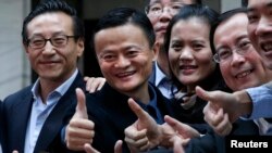 ស្ថាបនិក​ក្រុមហ៊ុន Alibaba លោក Jack Ma (កណ្តាល) ថត​រូប​នៅ​ពេល​ភាគ​ហ៊ុន​របស់​ក្រុម​ហ៊ុន​នេះ​ត្រូវ​បាន​បើក​នៅ​ទីក្រុង​ញូវ​យ៉ក​កាល​ពី​ឆ្នាម២០១៤។