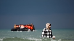 Seorang migran berjalan menuju perahu karet dalam upaya menyeberangi Selat Inggris untuk mencapai Inggris dari wilayah Wimereux, Prancis, pada 4 September 2024. (Foto: Reuters/Benoit Tessier)