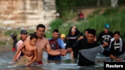 Migrantes venezolanos caminan por el río Grande en un intento de buscar asilo en EEUU, visto desde Piedras Negras, México, el 30 de septiembre de 2023. REUTERS/Daniel Becerril 