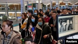 Passengers from China pass by a thermal screening point upon their arrival at Istanbul International Airport in Istanbul, Turkey, Jan. 24, 2020. 