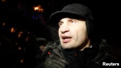 Heavyweight boxing champion and Ukrainian Democratic Alliance for Reform party leader Vitaly Klitschko walks past a riot police line in Kyiv, Dec. 11, 2013. 