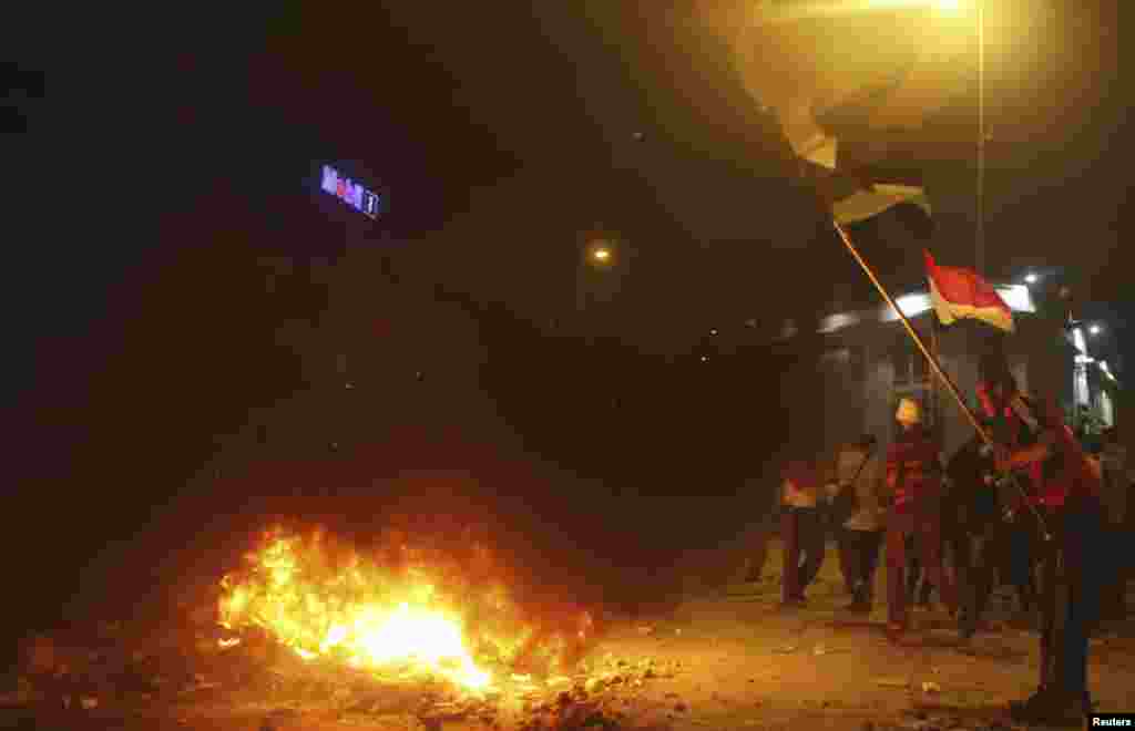 Supporters of Mohamed Morsi make a fire to stop the effects of tear gas fired by riot police in central Cairo, July 15, 2013.