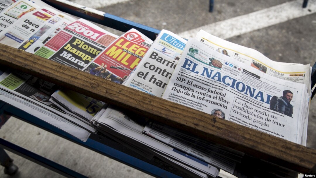 ARCHIVO - Una copia del diario El Nacional (derecha) se ve entre otras en un estante de un quiosco en Caracas el 14 de mayo de 2015. 