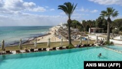 Un touriste nage dans la piscine d'un hôtel de la station balnéaire tunisienne d'Hammamet, à environ 66 kilomètres au sud de la capitale Tunis, le 7 octobre 2021.