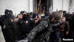 Members of law enforcement clash with pro-Trump protesters storming the U.S. Capitol, in Washington, Jan. 6, 2021.