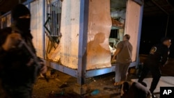 Palestinians check a damaged police container following an explosion targeted a Hamas police checkpoint in Gaza City, Aug. 28, 2019.