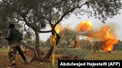 SYRIA -- Members of Syria's opposition "National Liberation Front" fire heavy artillery guns at government forces in northeastern Idlib province, February 28, 2020