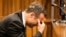 Oscar Pistorius, puts his hand to his face while listening to evidence from a witness on the fourth day of his trial at the high court in Pretoria, South Africa, March 6, 2014. 