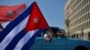 Cubanos pasan frente a la embajada de Estados Unidos durante una manifestación que pide el fin del bloqueo de Estados Unidos contra Cuba, en La Habana, 28 de marzo de 2021. [Foto de YAMIL LAGE / AFP]