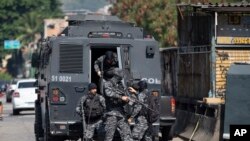 La policía sale de un vehículo blindado durante una operación contra presuntos narcotraficantes en la favela Jacarezinho de Río de Janeiro, Brasil, el jueves 6 de mayo de 2021.