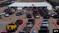 FILE - Cars line up for COVID-19 tests at the University of Texas, El Paso, Oct. 23, 2020.