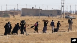 Syrian refugees depart border area after waiting for several hours in failed bid to enter Akcakale, Sanliurfa province, Turkey, June 12, 2015.